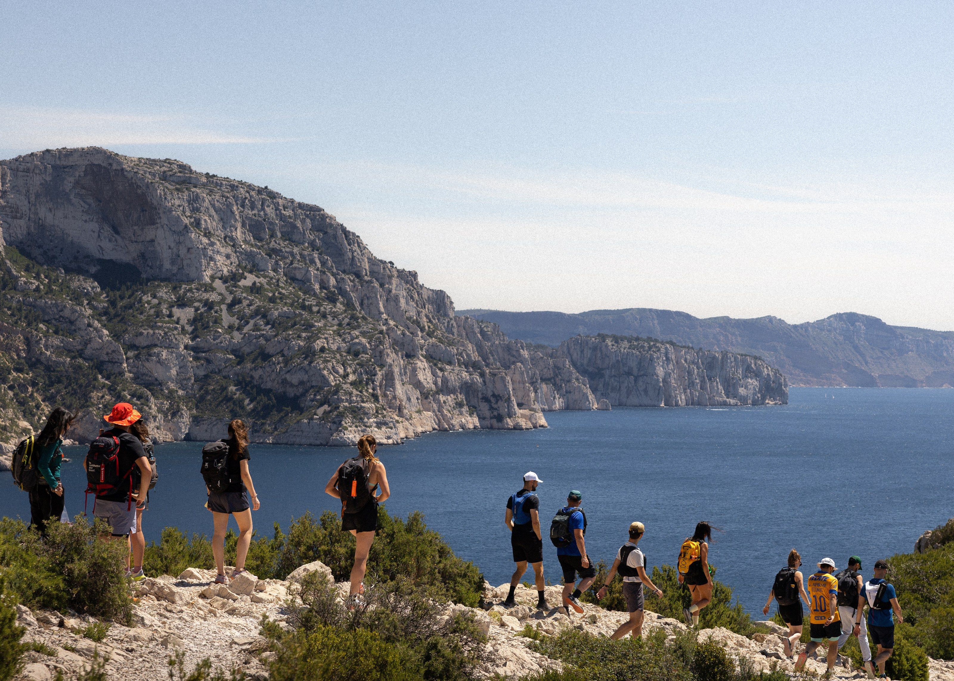 Le groupe en randonnée au bord des falaises des Calanques, la mer en contrebas.
