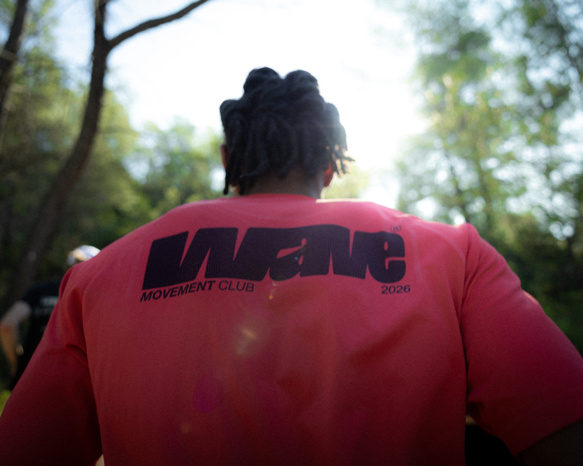 Le dos du T-shirt rouge WAVE 2026, floqué WAVE Movement Club 2026, porté pendant un run.