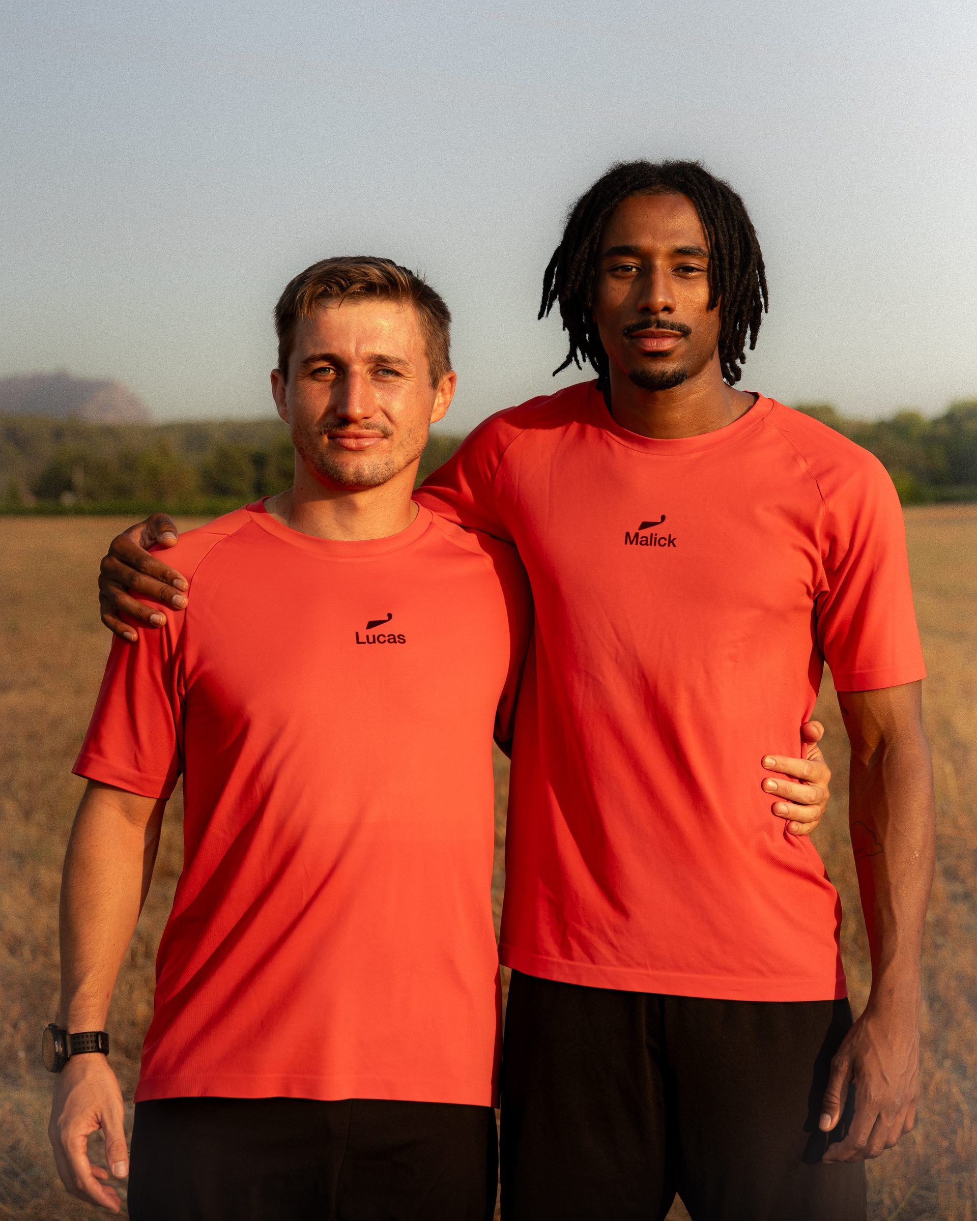 Les deux fondateurs de WAVE en maillot rouge, dans un champ en fin de journée.