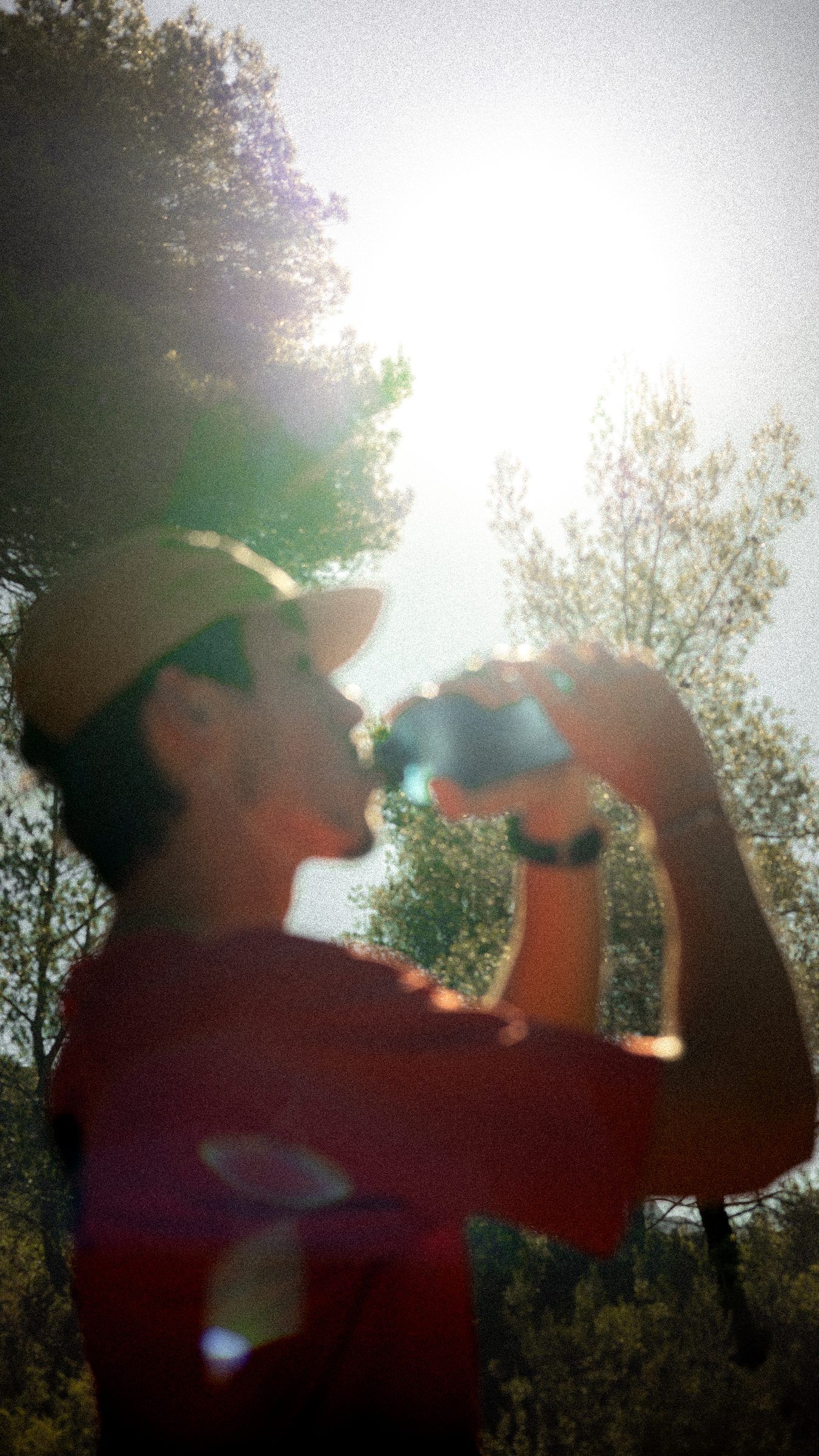 Un coureur boit à contre-jour pendant une pause.