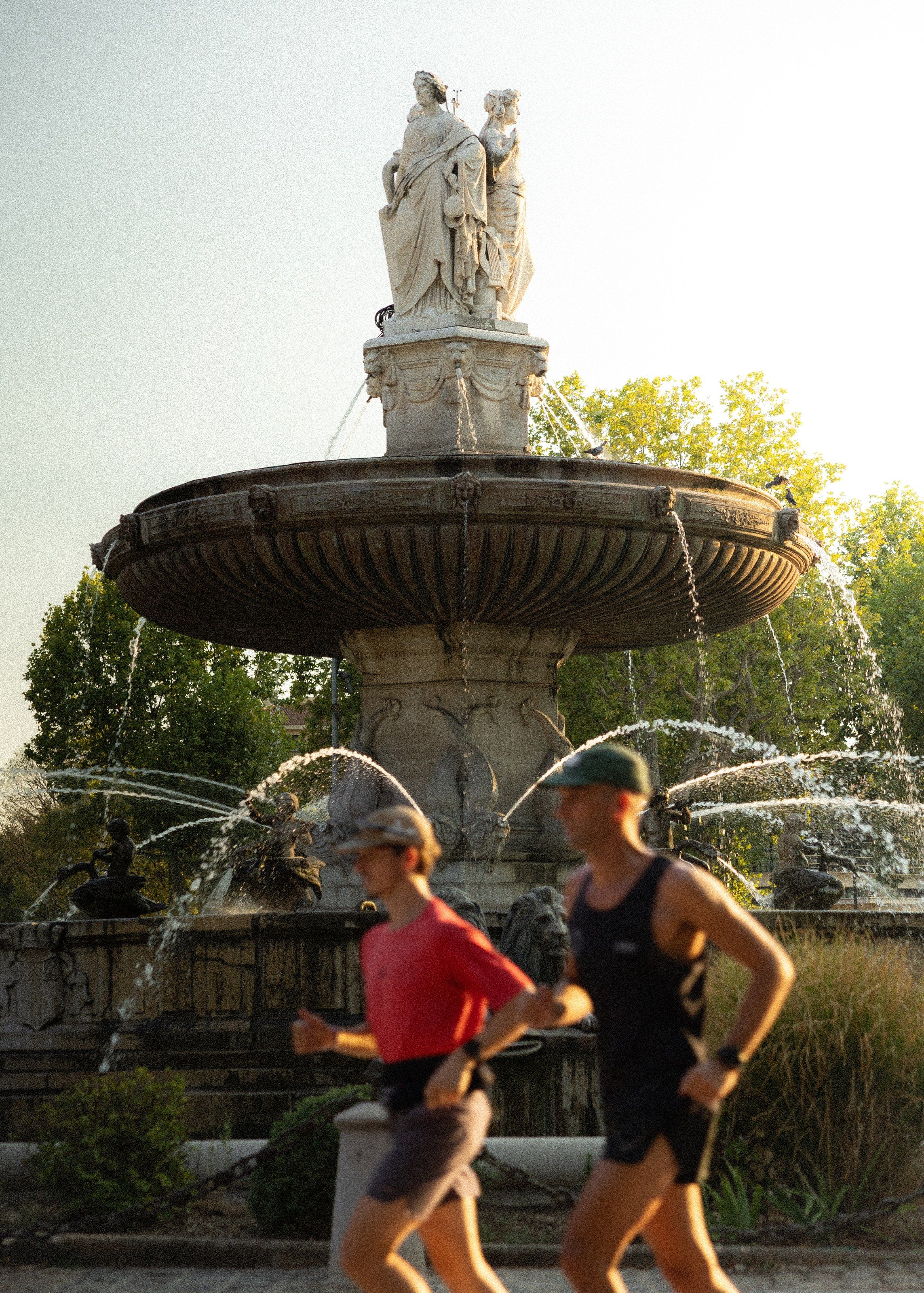 Deux coureurs passent devant la fontaine de la Rotonde.